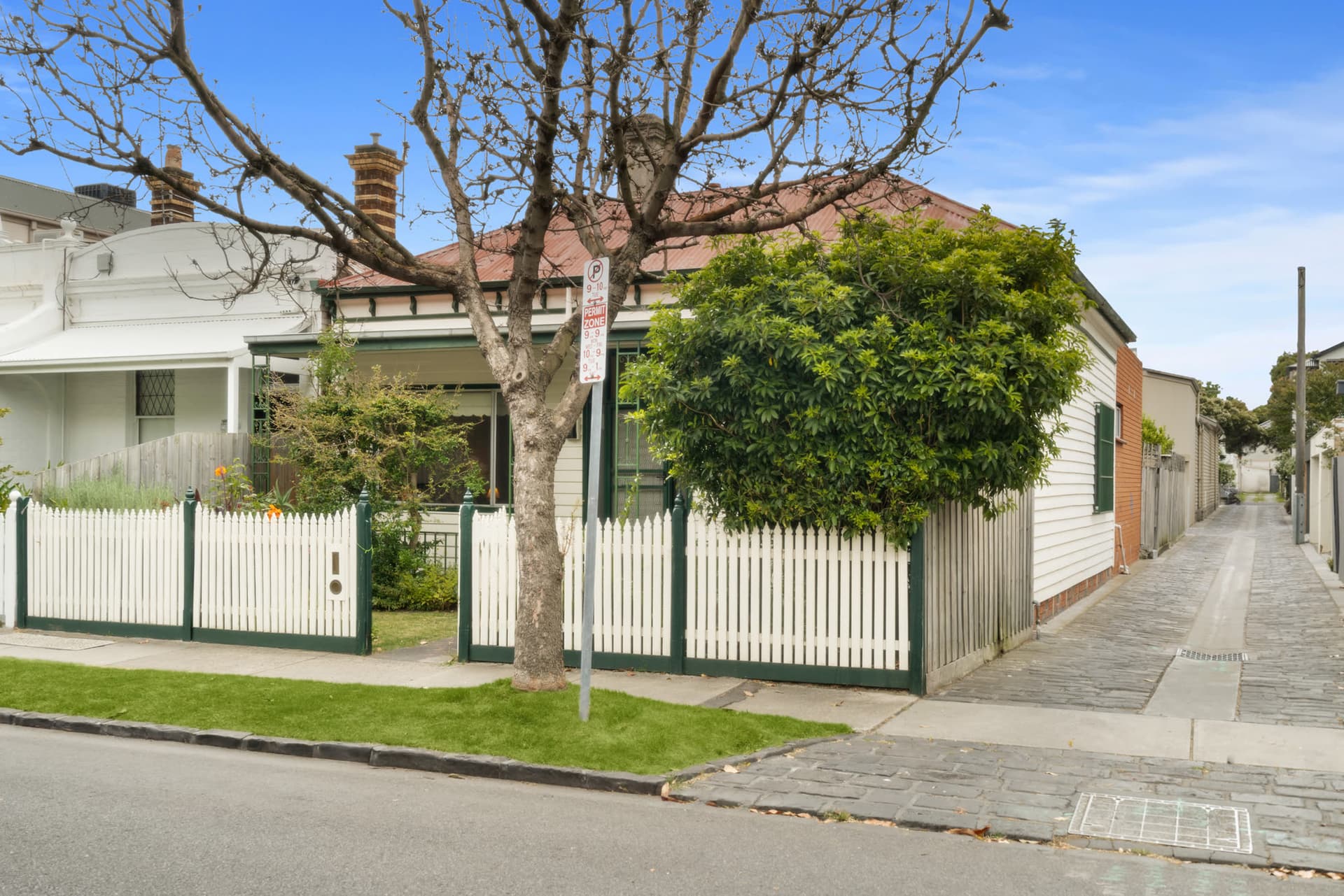 A Victorian cottage behind a white picket fence